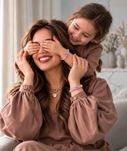 Speelse moeder dochterknuffel met paarse armbandjes | Enjoia