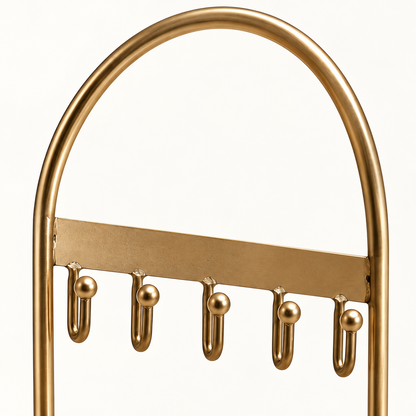 Detail van het gebogen goudkleurige frame en de ophanghaakjes van de sieradenhouder
